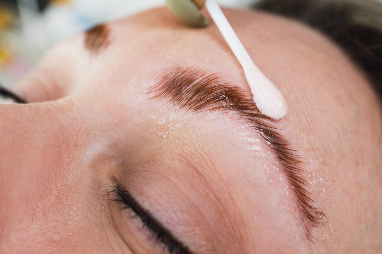 A close view of a brow treatment applied with a fine applicator.